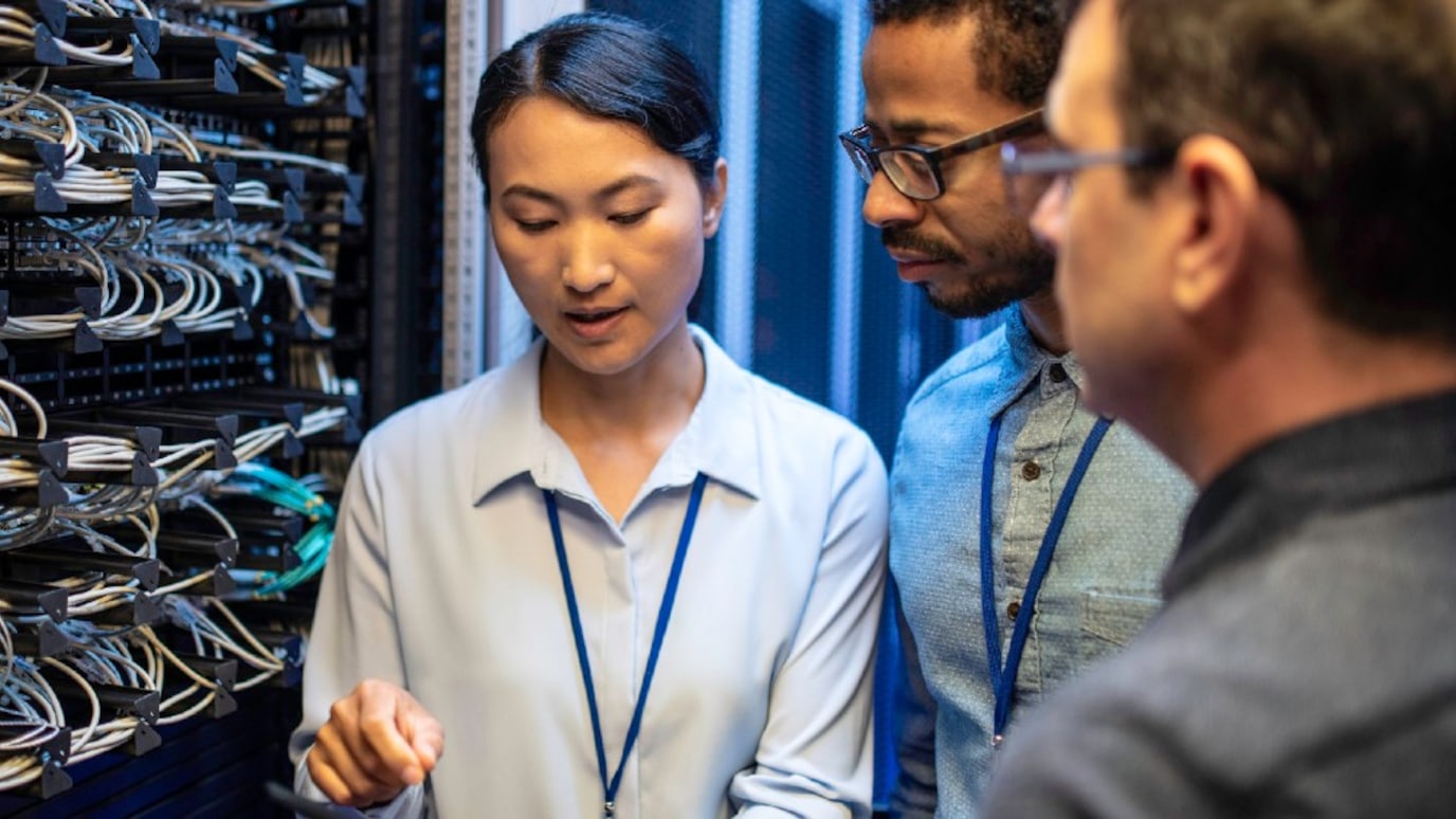 Engineers in discussion in front of server rack