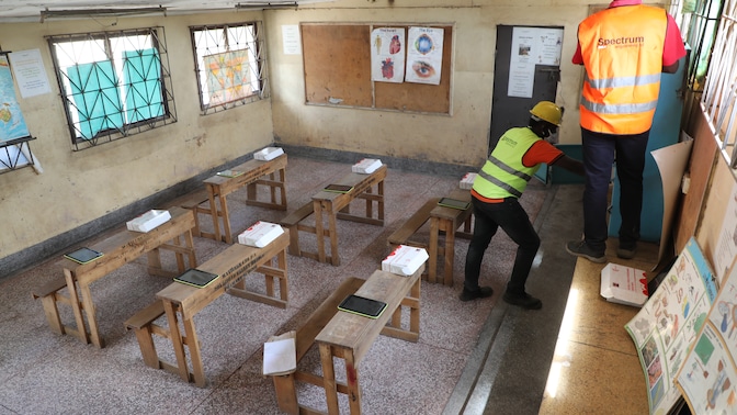 Technicians finish up installation of internet router at Valley Bridge primary school computer library in Mathare