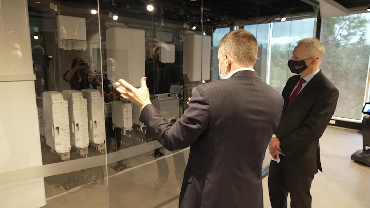 Minister Fletcher and Rob Joyce in 5G Futures Lab at Equipment Room window