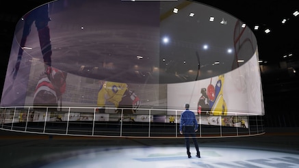 man in front of large screens