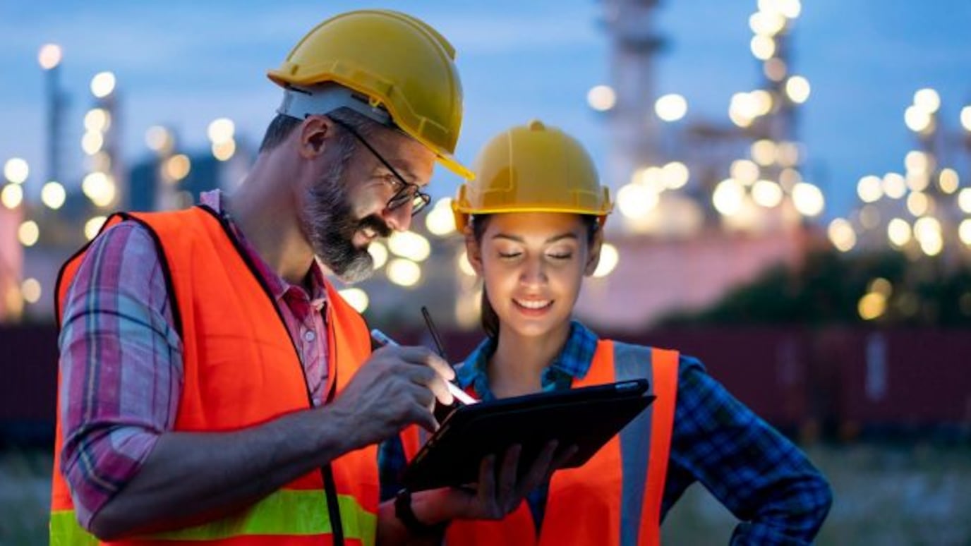 Two engineers are discussing outside the chemical plant