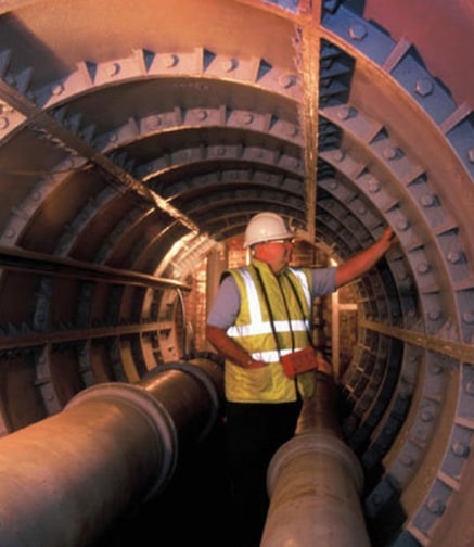 Engineer standing in tunnel inspecting water pipes