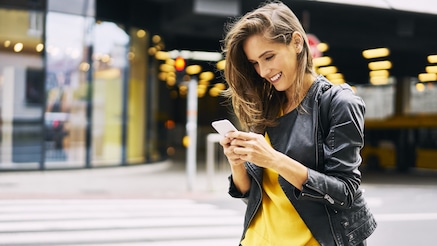 A person looking at their phone smiling.