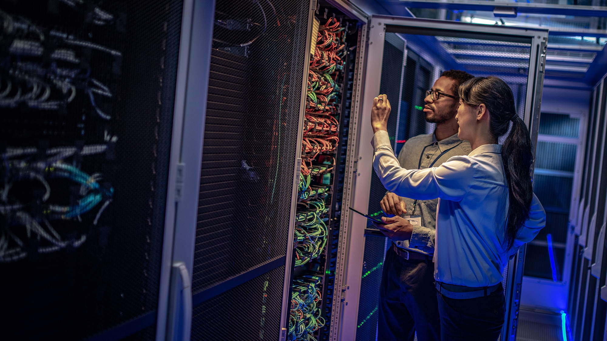 Two people checking servers.