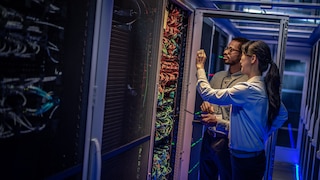 Two people checking servers.