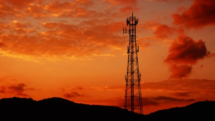 Antenna tower silhouetted against sunset