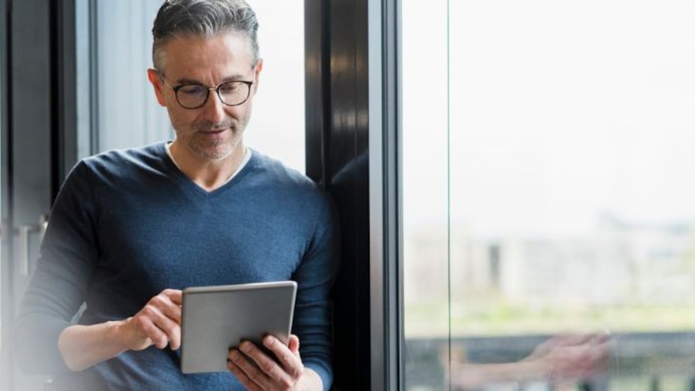 Man scrolling on a tablet in an office