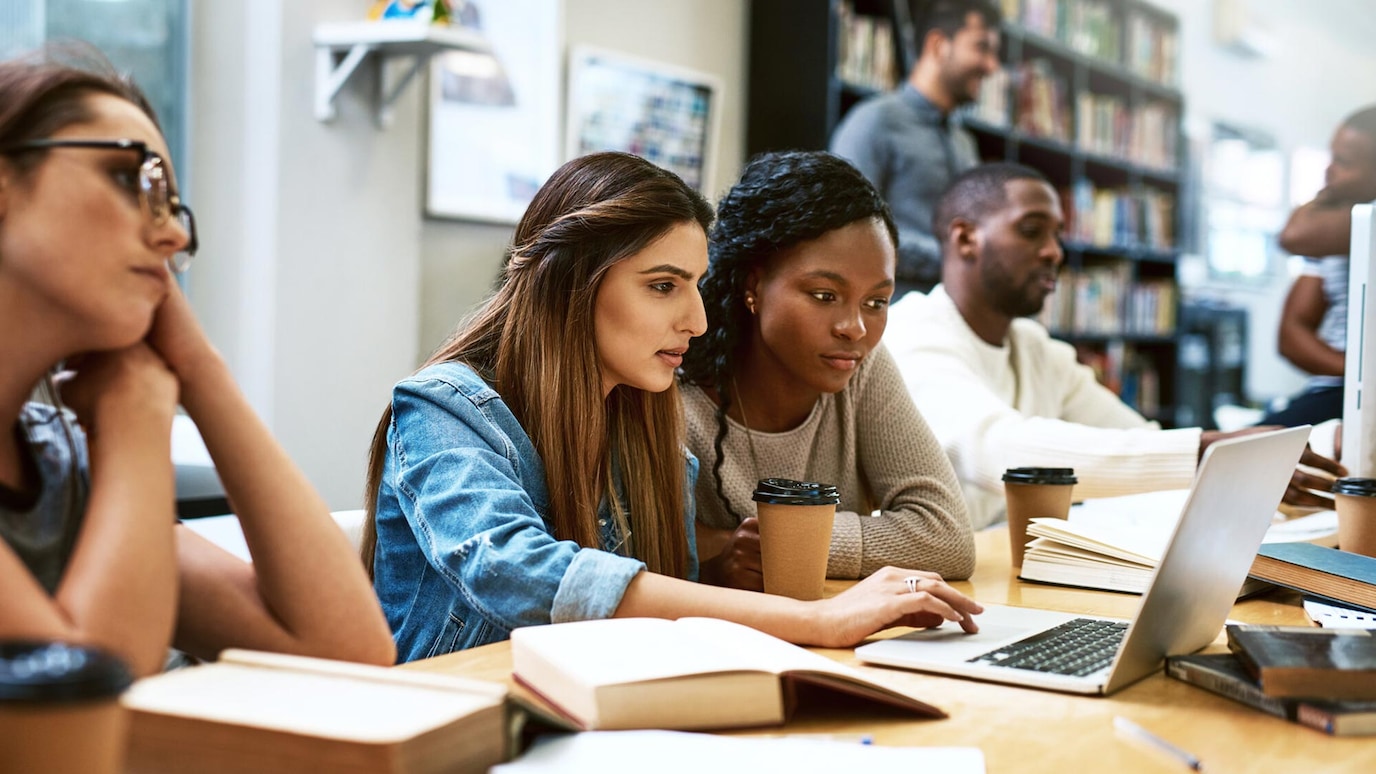 Students looking at laptop in classroom