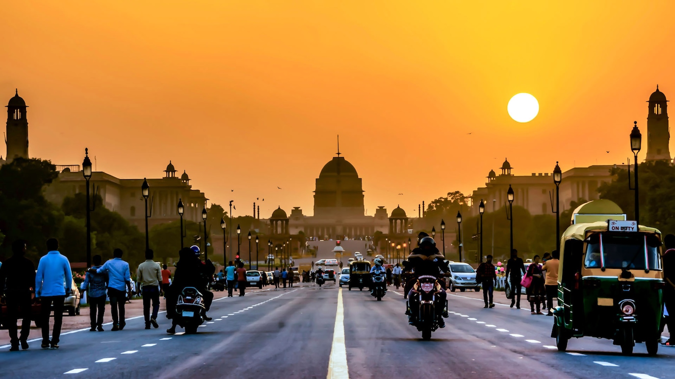 View down middle of a road leading to a civic building at sunset