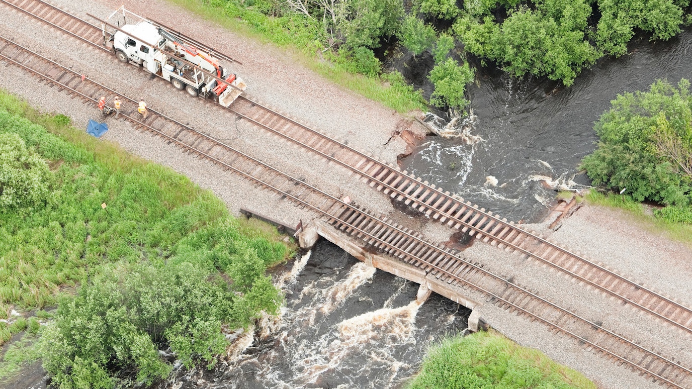 Repair vehicle on rail tracks on damaged bridge over river