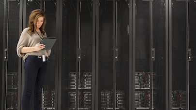 Technician checking tablet device in server room