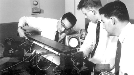 Ali Javan (left) works with an early laser while other researchers look on.