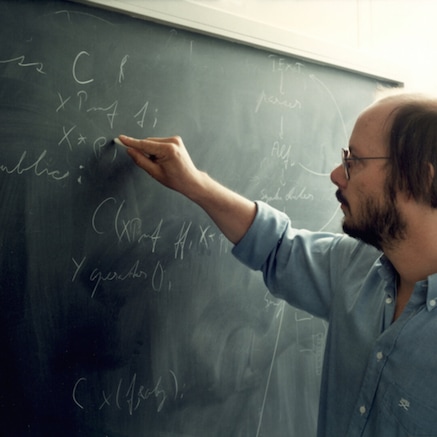 Bjarne Stroustrup writing on a chalk board