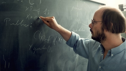 Bjarne Stroustrup writing on a chalk board