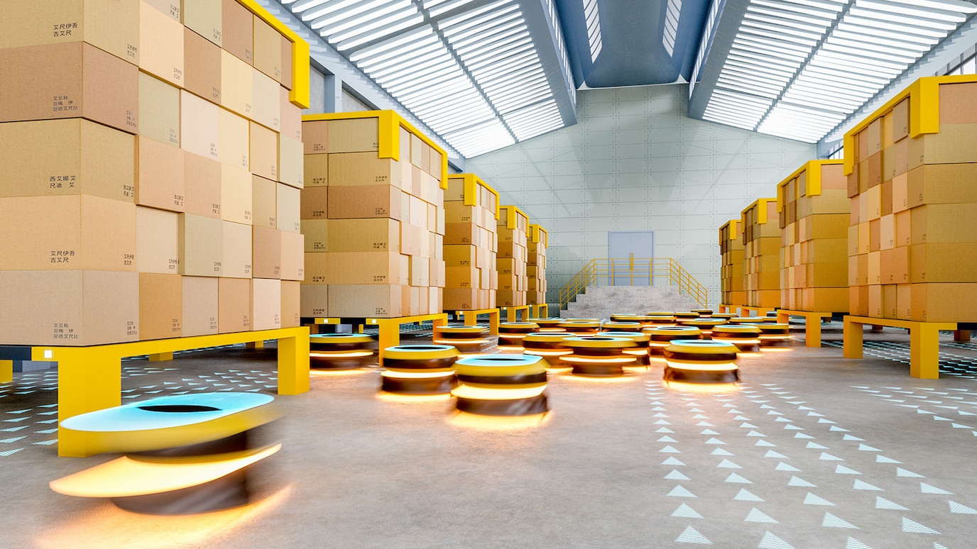 Warehouse interior with automated robots moving between tall stacks of cardboard boxes on yellow shelves, under a high ceiling with skylights