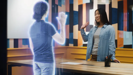 Person waving at a hologram of a person