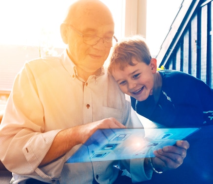 An elderly man and a young boy using a digtial tablet together