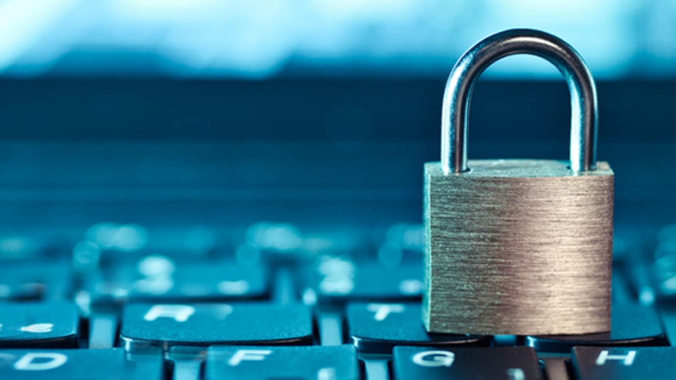 A close-up image of a physical lock placed on top of a keyboard, symbolizing security