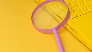 laptop with a pink magnifying glass on it