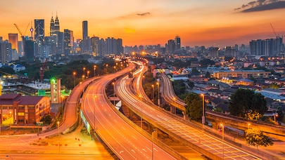 Highway leading into city at sunset