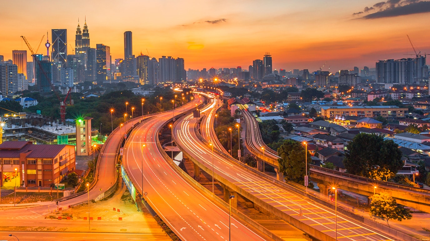 Highway leading into city at sunset