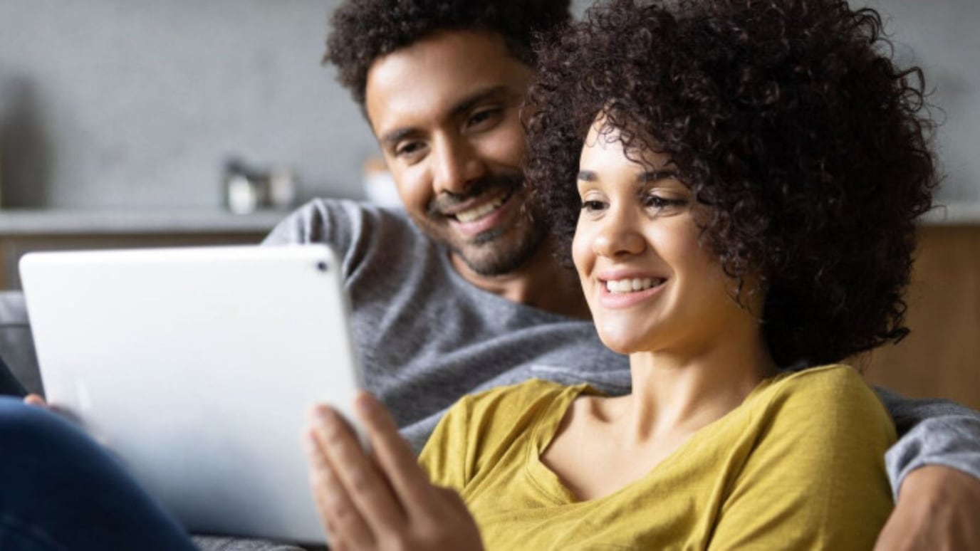 A smiling couple looking at a tablet