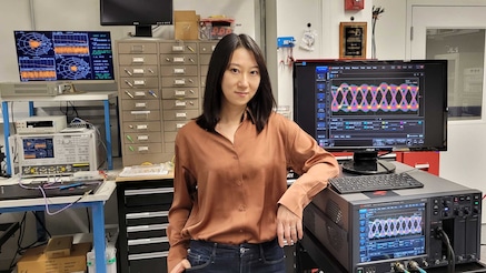 Qian Hu in front of lab equipment