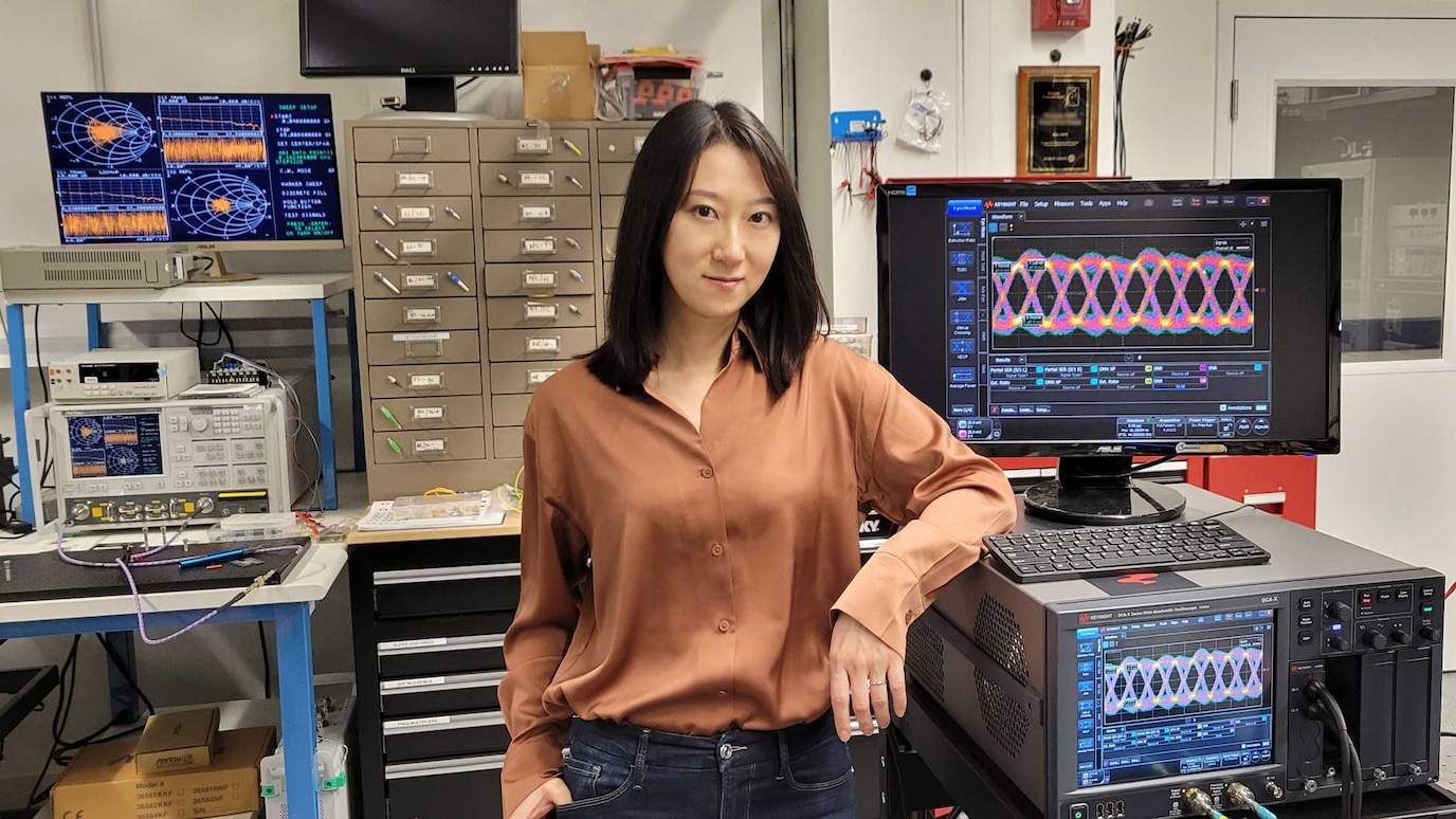 Qian Hu in front of lab equipment