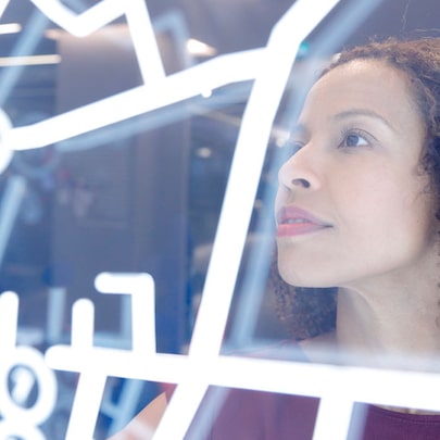 Profile view of a person gazing upward thoughtfully through a geometric pattern of white lines or framework.