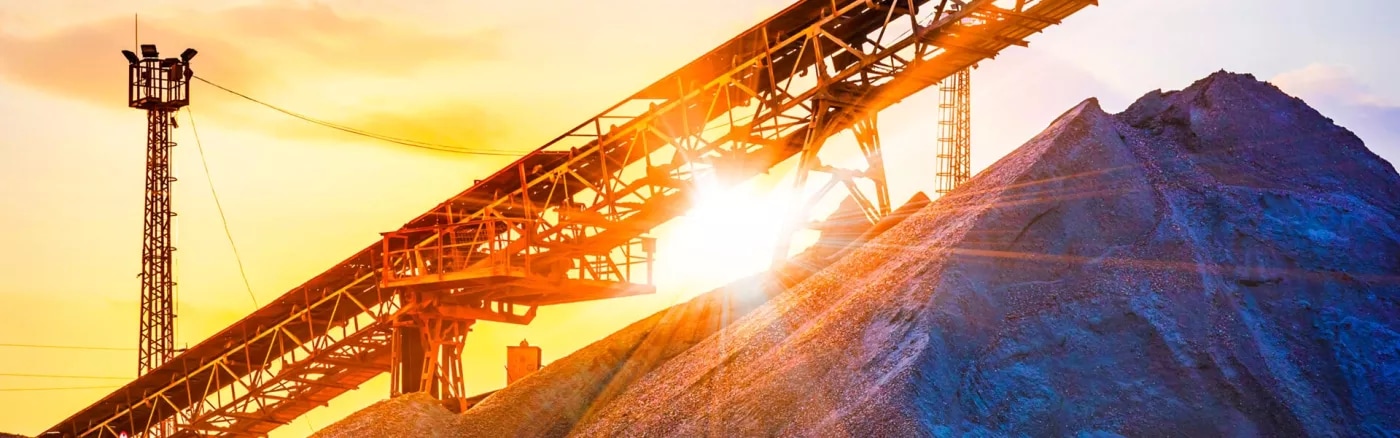 An image of a haulage system on a mountain top with a sunset in the background.