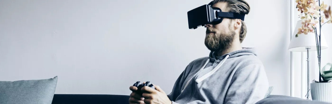 A person playing on a coonsole with a VR headset on.