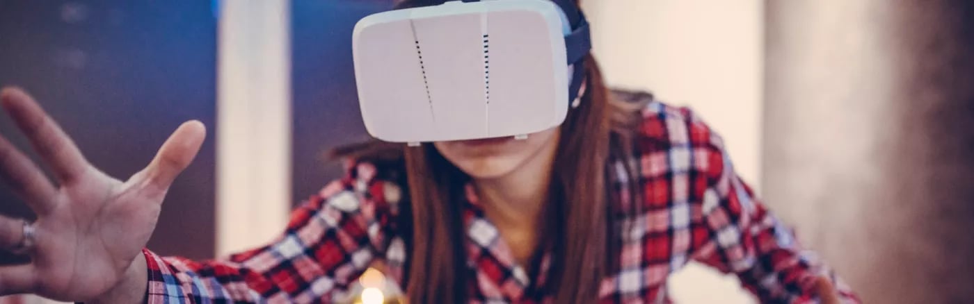 A picture of a person in a red plaid shirt wearing a VR headset.