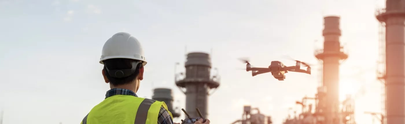 A person wearing safety gear flying a drone.