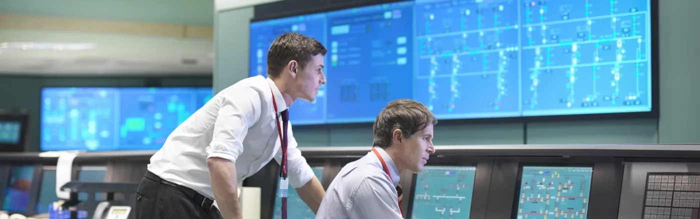 Two people working and looking at the same computer screen.