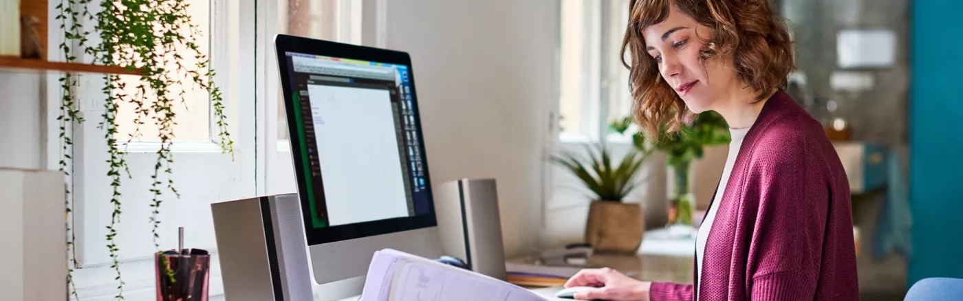 A picture of a person working in a bright home office setting.