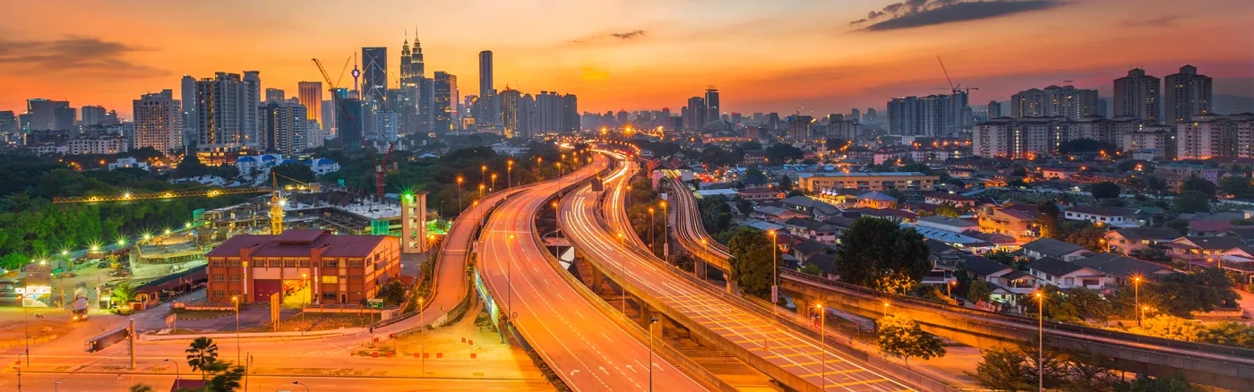 Highway leading into city at sunset