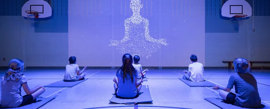 Kids doing yoga in a gymnasium