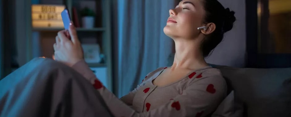 Woman holding a smartphone in her hands and listening to music