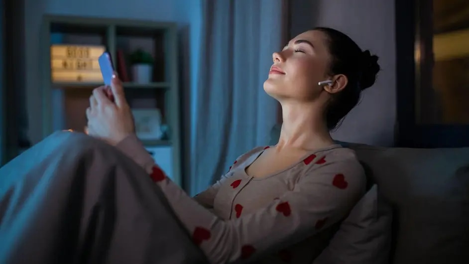 Woman holding a smartphone in her hands and listening to music