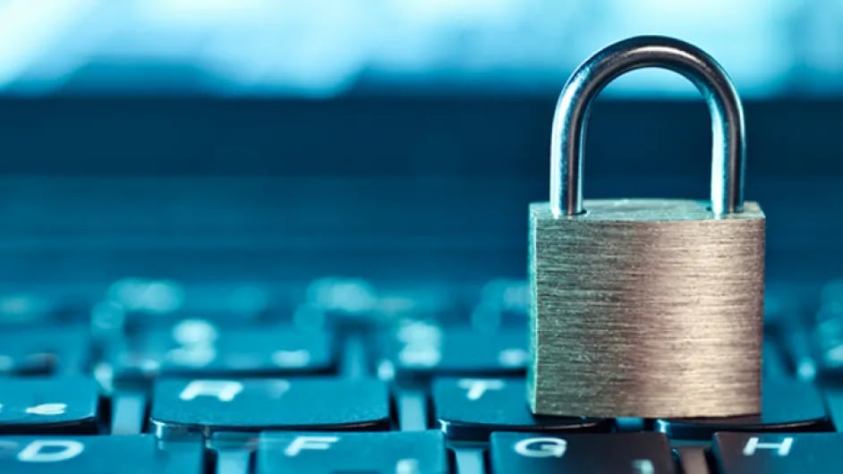 A close-up image of a physical lock placed on top of a keyboard, symbolizing security